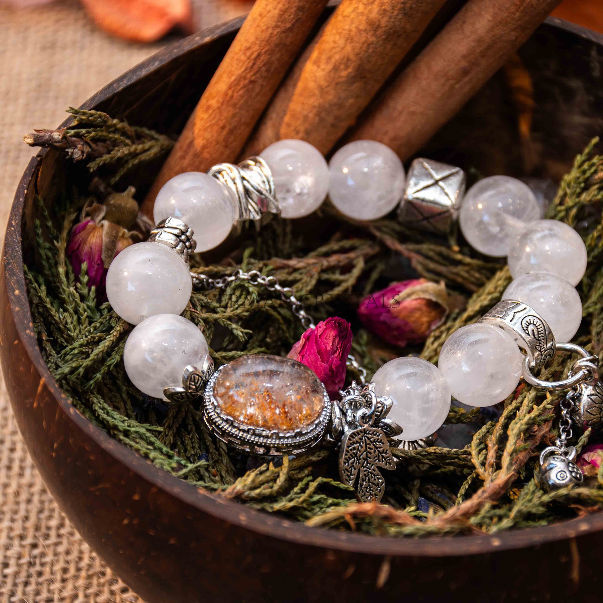 White and Garden Phantom Quartz bracelet with Magic Box centerpiece, silver accents, resting on herbs and dried flowers in wooden bowl