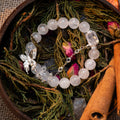 Phantom Quartz and Clear Quartz beaded bracelet with silver butterfly charm on dried greenery and cinnamon sticks background