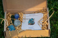 Set of polished blue and turquoise Apatite stones in craft box with information card on grass background