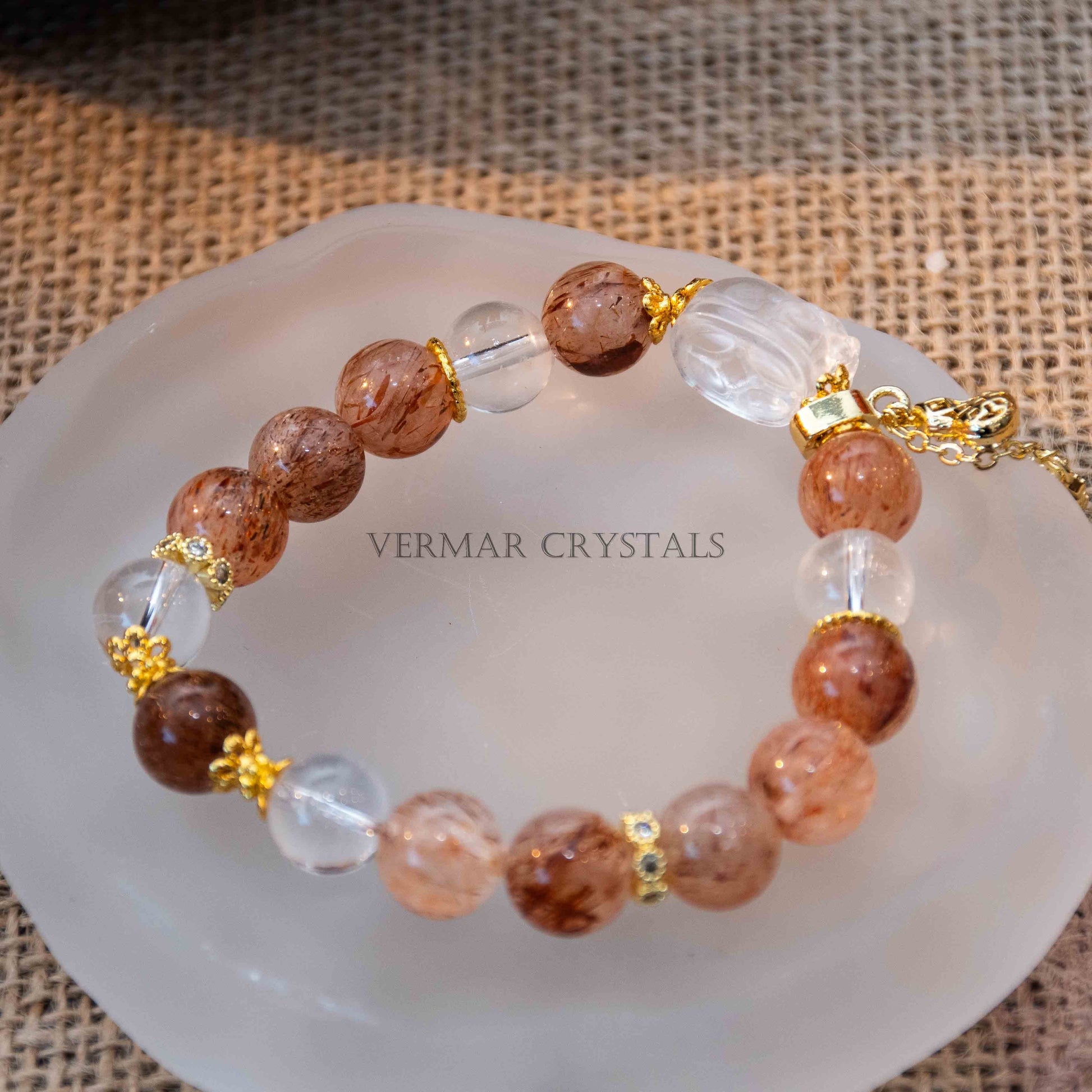 Close-up of Autumn Sunlight Bracelet with 10mm black rutilated quartz and clear quartz beads on frosted plate