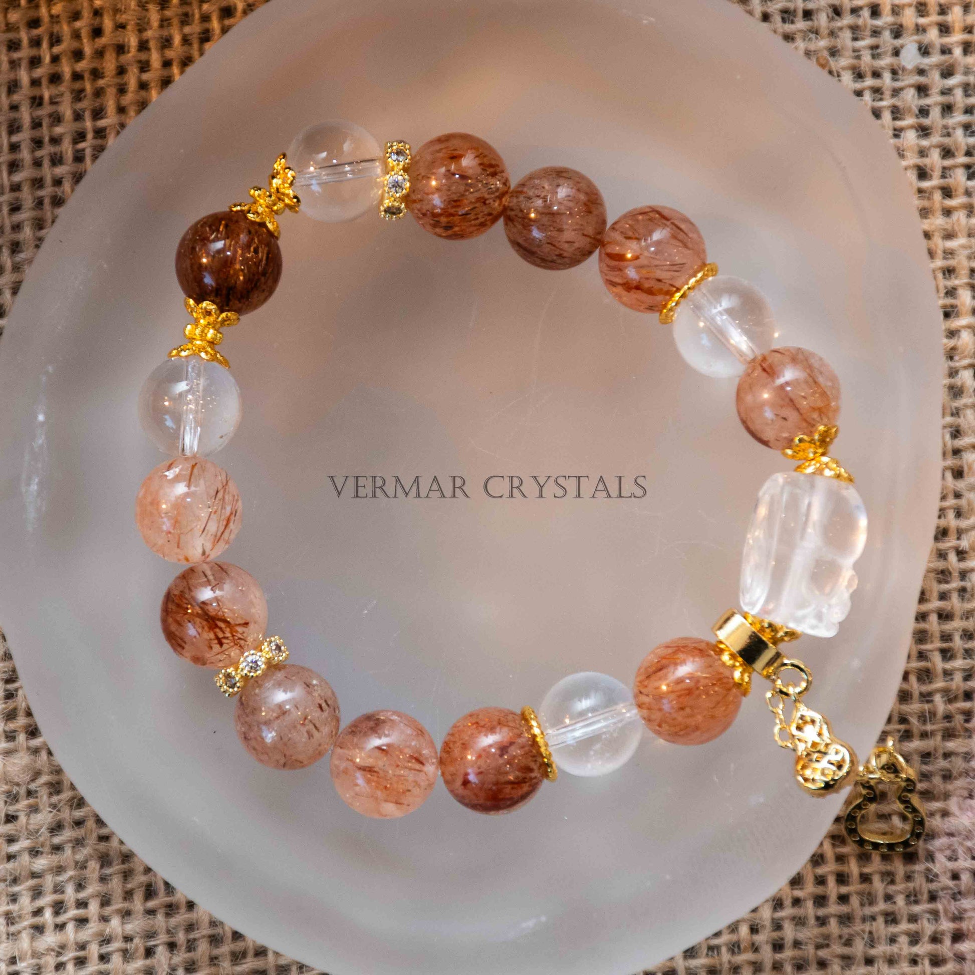 Close-up of Autumn Sunlight Bracelet with 10mm black rutilated quartz and clear quartz beads on frosted glass dish