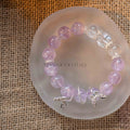 Lavender amethyst beaded bracelet with silver leaf charms resting on frosted round dish over burlap background