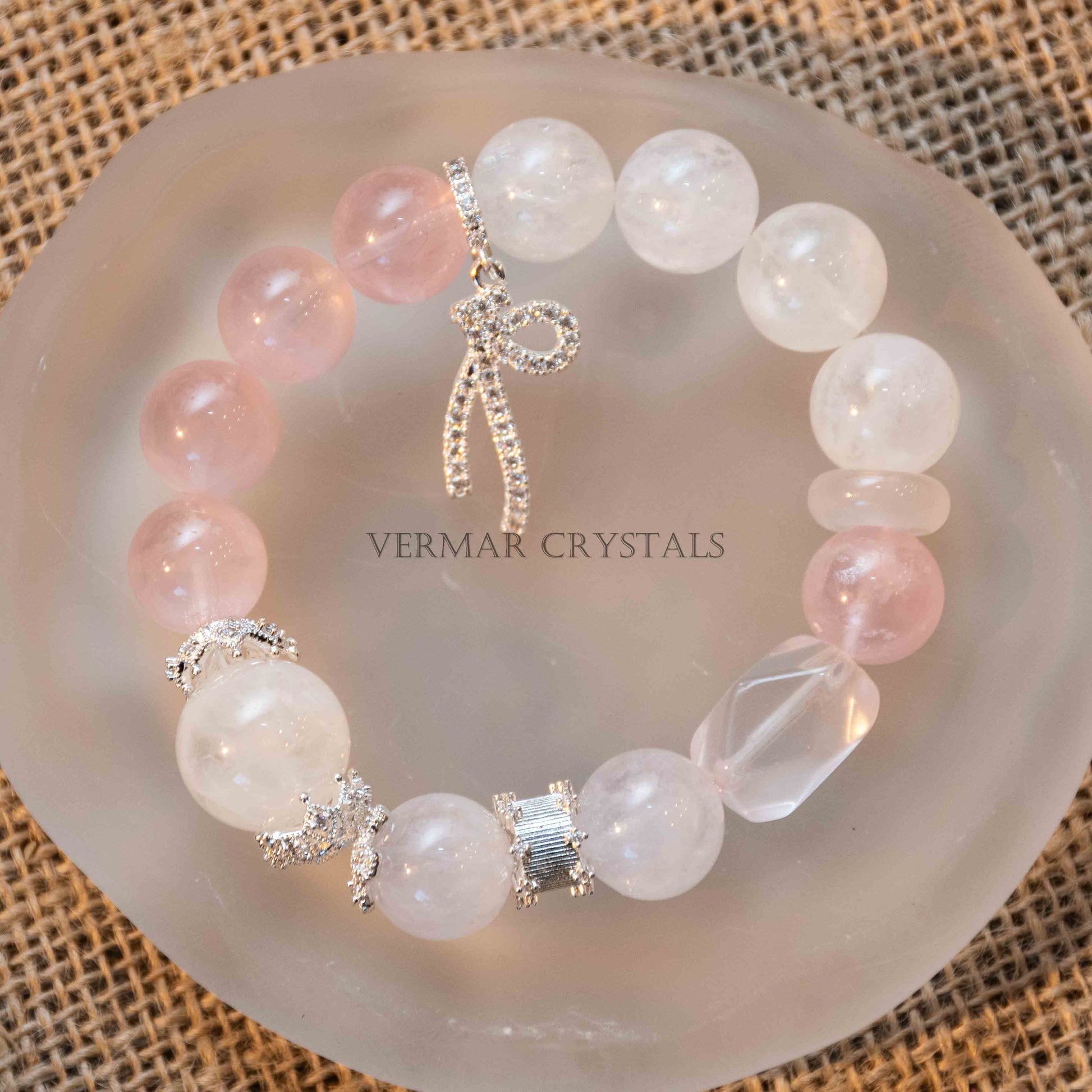 Rose Quartz and White Phantom Quartz beaded bracelet with silver spacer charms on round frosted dish
