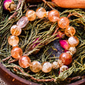 Yellow Calcite beaded bracelet with gold accents displayed on dried greenery and rosebuds in wooden bowl
