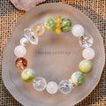 Handmade bracelet with fresh green and cream white serpentine jade beads and clear quartz on frosted stone dish