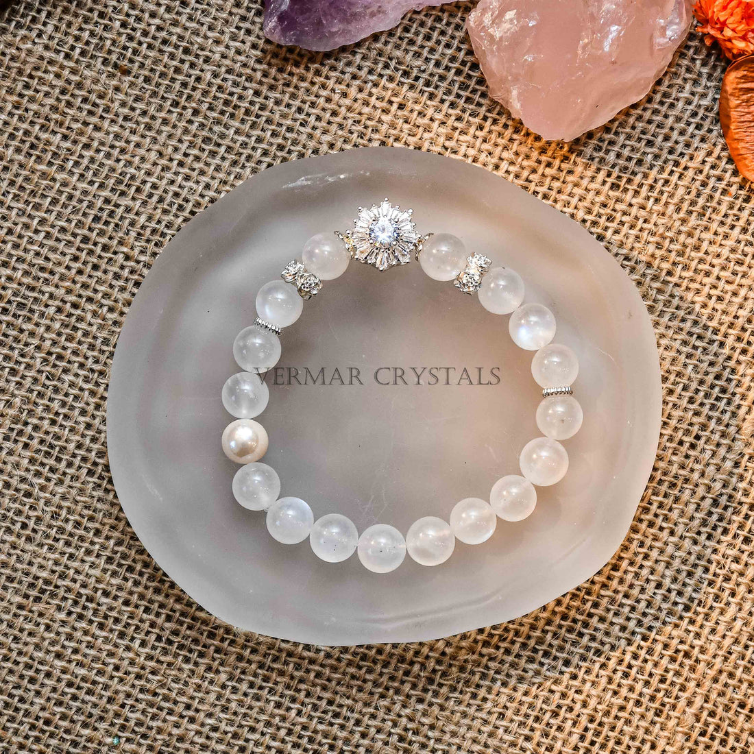 Blue Moonstone and freshwater pearl beaded bracelet with a central silver zircon charm on fabric in wooden tray