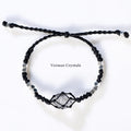 Handcrafted Herkimer Diamond crystal wrapped in black braided cord with silver bead accents on adjustable bracelet against white background