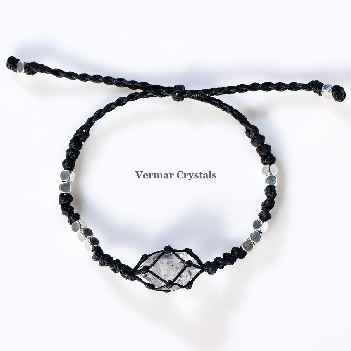 Handcrafted Herkimer Diamond crystal wrapped in black braided cord with silver bead accents on adjustable bracelet against white background