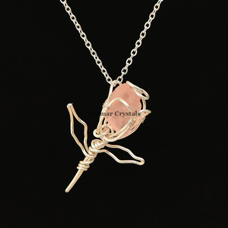 Handcrafted rose quartz rose pendant wrapped in silver wire on a delicate silver chain necklace against a white background