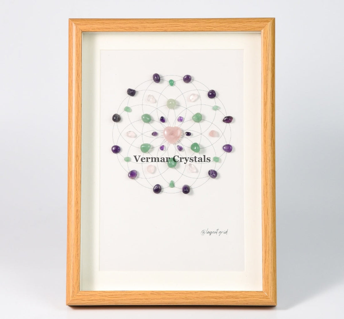 Love and Harmony crystal grid painting with rose quartz, green aventurine, and amethyst in a wooden frame on white background
