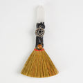 Handcrafted mini ritual witch broom with natural straw, clear quartz point, pentacle charm, and tiger's eye stone on white background