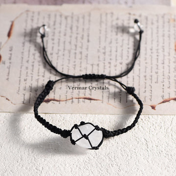 Handmade clear quartz stone secured in a black net-wrapped adjustable bracelet on a textured background