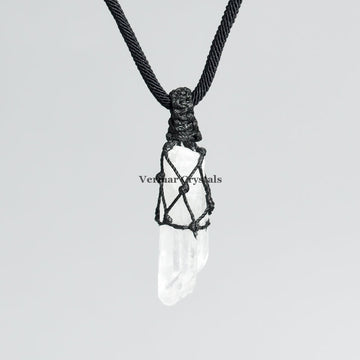 Clear quartz point pendant wrapped in black hand-woven cord on simple black necklace against light background