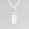 Raw clear quartz point pendant wrapped in white macramé cord on light gray background