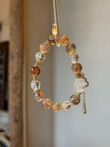 Close-up of Autumn Sunlight Bracelet with 10mm natural black rutilated quartz and clear quartz beads on neutral background