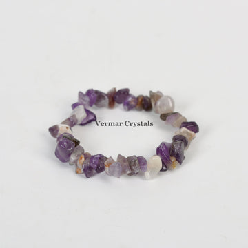 Handmade stretchy bracelet with irregular polished amethyst chip stones in various purple shades on white background
