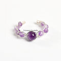 Handmade adjustable amethyst braided ring with polished round and oval purple stones on a white background