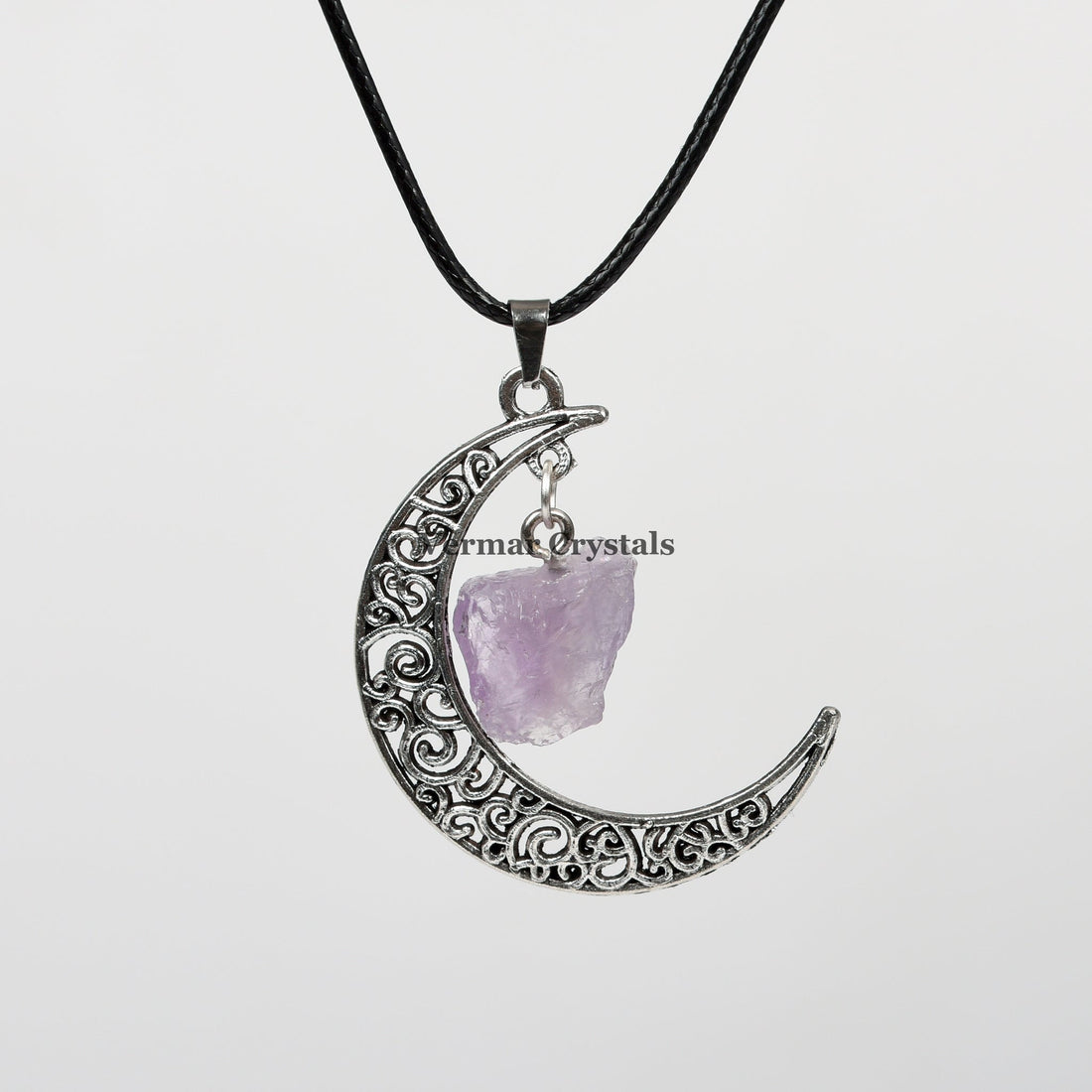 Handcrafted amethyst raw crystal pendant hanging inside a filigree silver crescent moon on a black cord necklace
