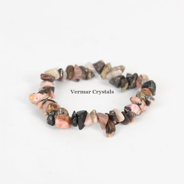 Handmade stretchy bracelet made of irregular polished pink, black, and brown rhodonite chip stones on a white background