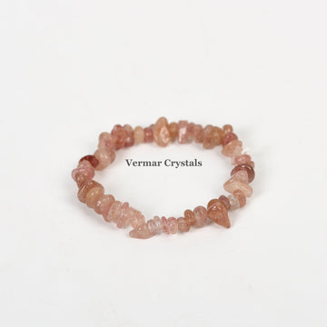 Stretchy handmade bracelet made of irregular polished pink and reddish strawberry quartz chip beads on white background