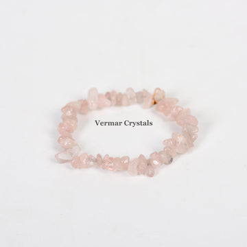 Handmade stretchy bracelet made of irregular pale pink rose quartz chip beads on a white background