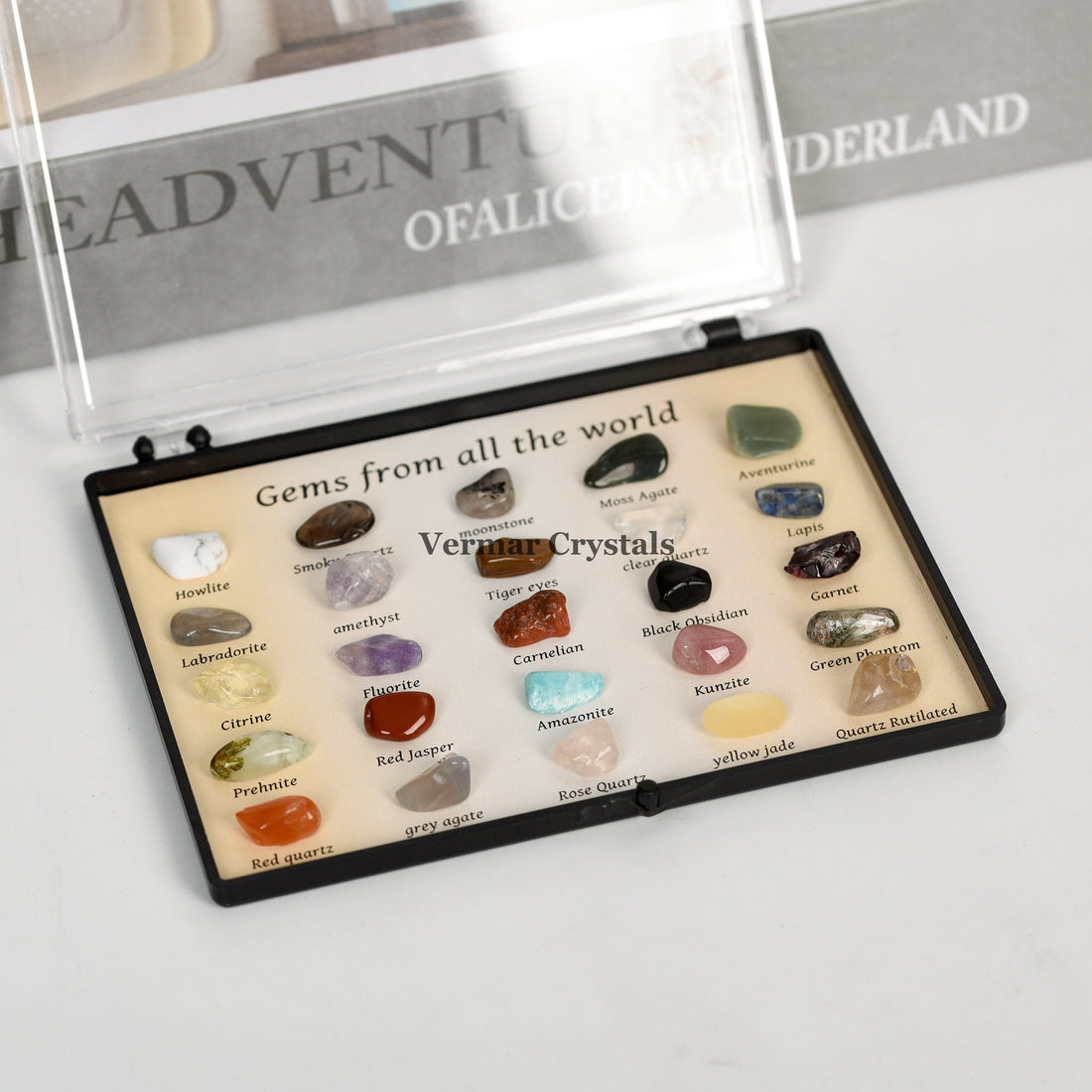 Crystal and gemstone specimen box displaying labeled natural stones from around the world in a compact black case