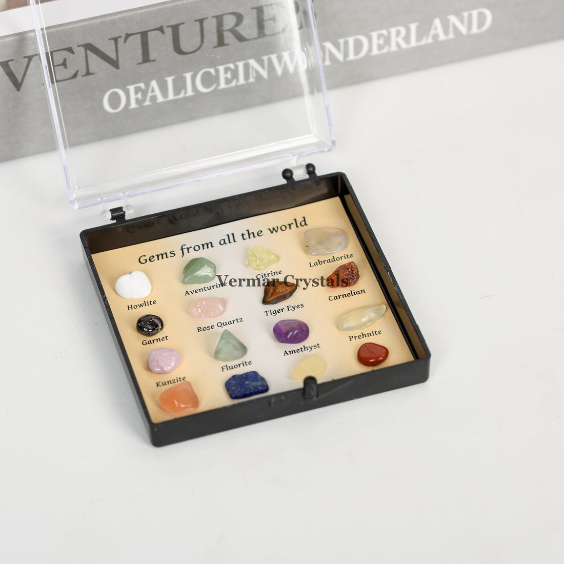 Crystal and gemstone specimen box displaying labeled natural stones from around the world in a compact black case